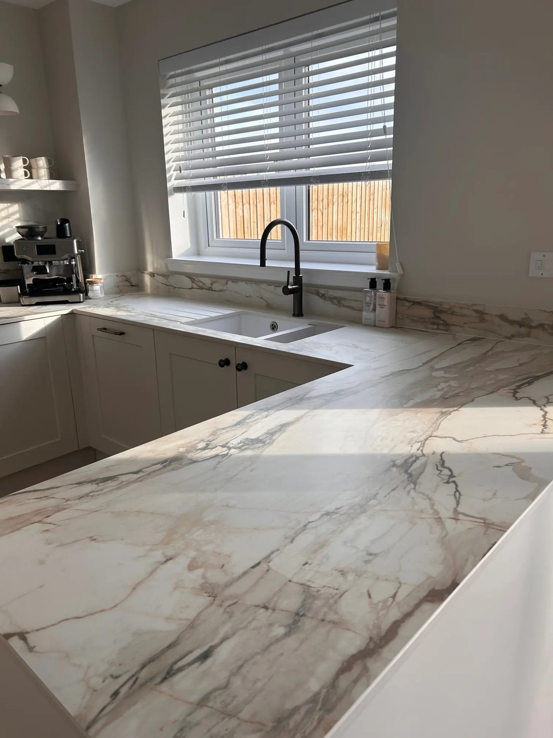 Marble-look veining across a Marmo Antico porcelain peninsula worktop